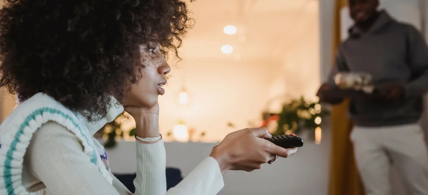 Teste IPTV Android: mulher trocando de canal com o controle durante o teste grátis